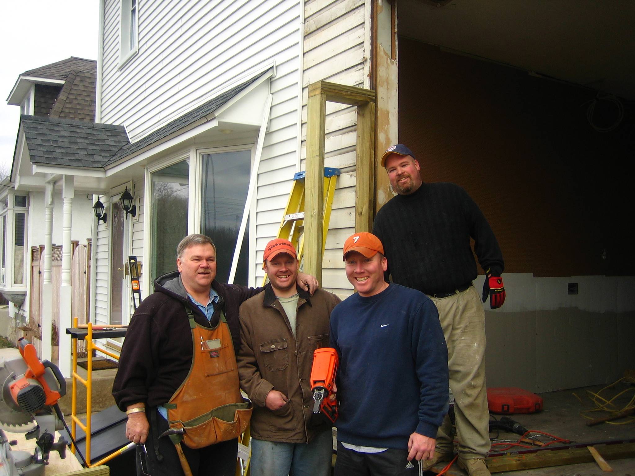 Four men standing in front of a house.